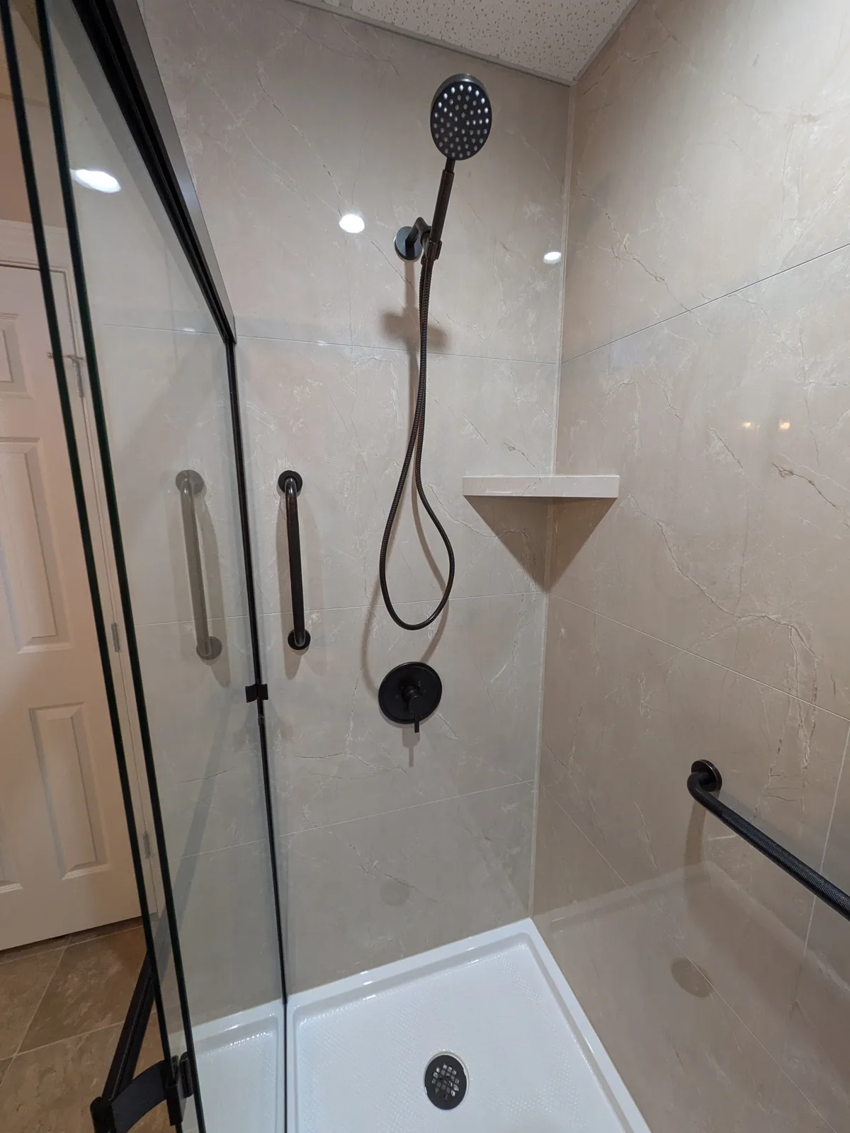 Completed shower alcove with bronze frame and low-threshold base